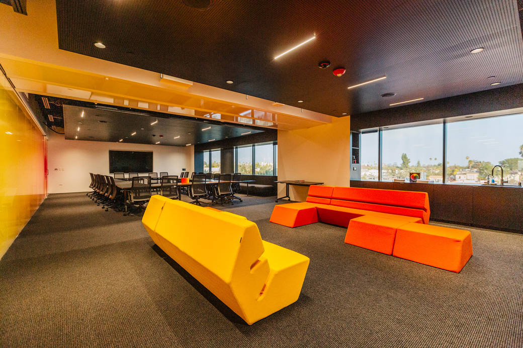 alumni lounge at ArtCenter featuring orange couches and a view of the san gabriel mountains